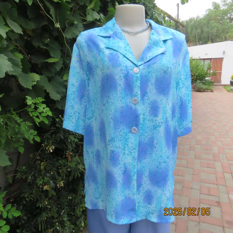 Fabulous button down-open collar top in medley of blue patterns. Size 40. Soft polyester.As new