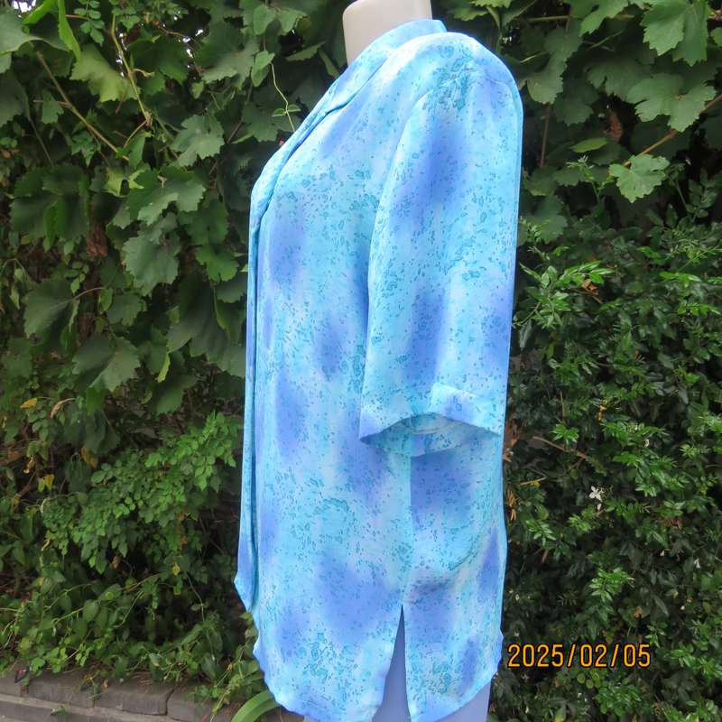 Fabulous button down-open collar top in medley of blue patterns. Size 40. Soft polyester.As new