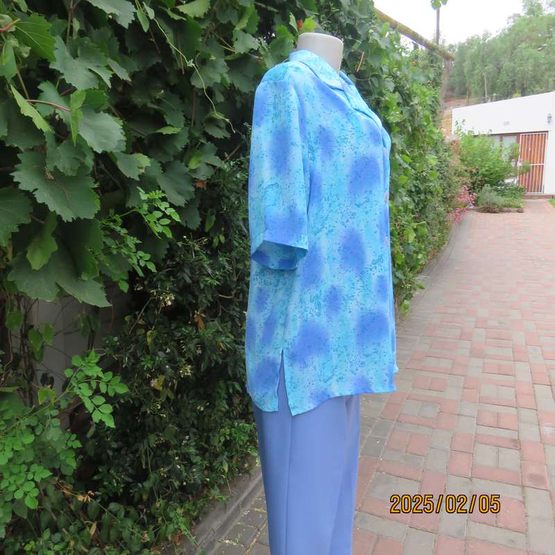 Fabulous button down-open collar top in medley of blue patterns. Size 40. Soft polyester.As new
