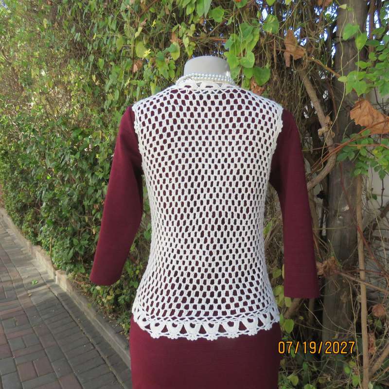 White elegant crochet waistcoat with round edging. The button closure. Size 34-36