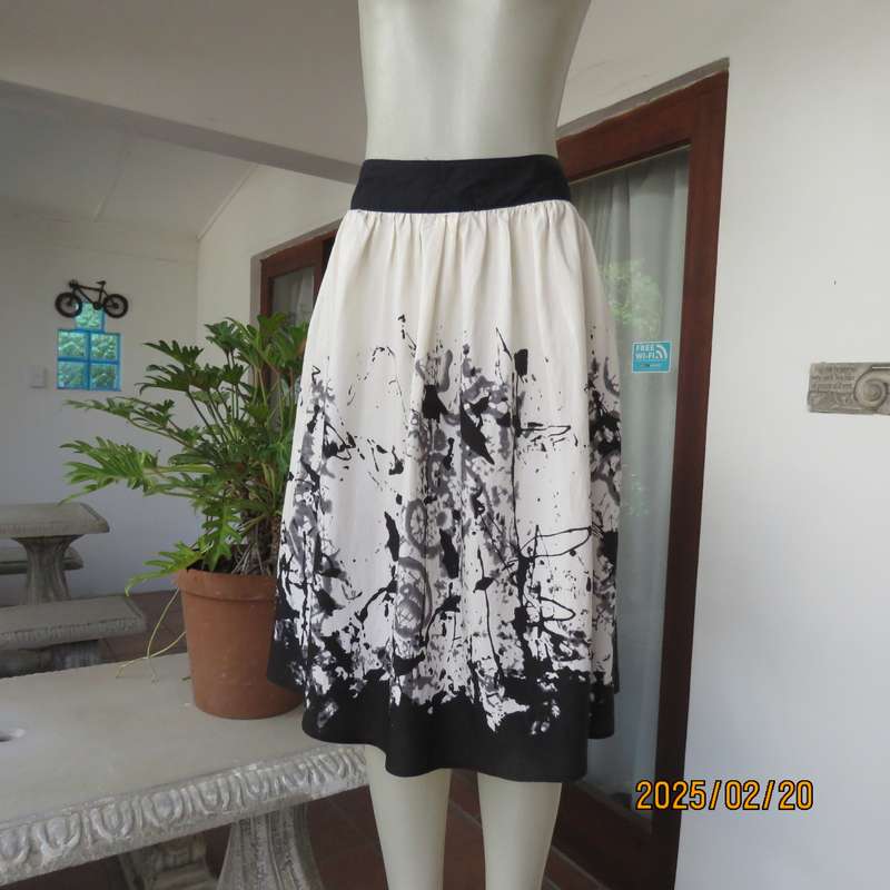 Unique rich cream size 42 viscose-nylon silky calf length skirt with graphic black print-border.