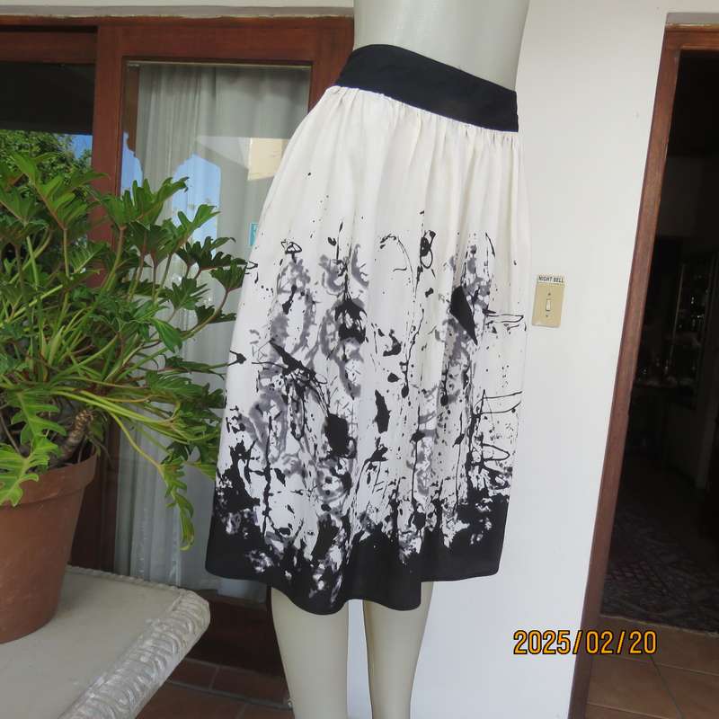 Unique rich cream size 42 viscose-nylon silky calf length skirt with graphic black print-border.