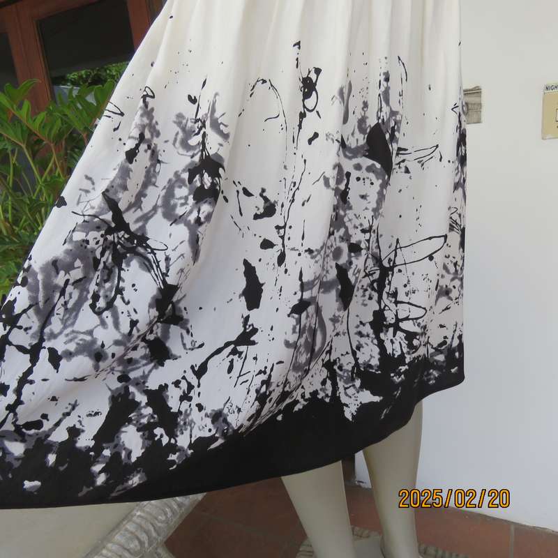 Unique rich cream size 42 viscose-nylon silky calf length skirt with graphic black print-border.
