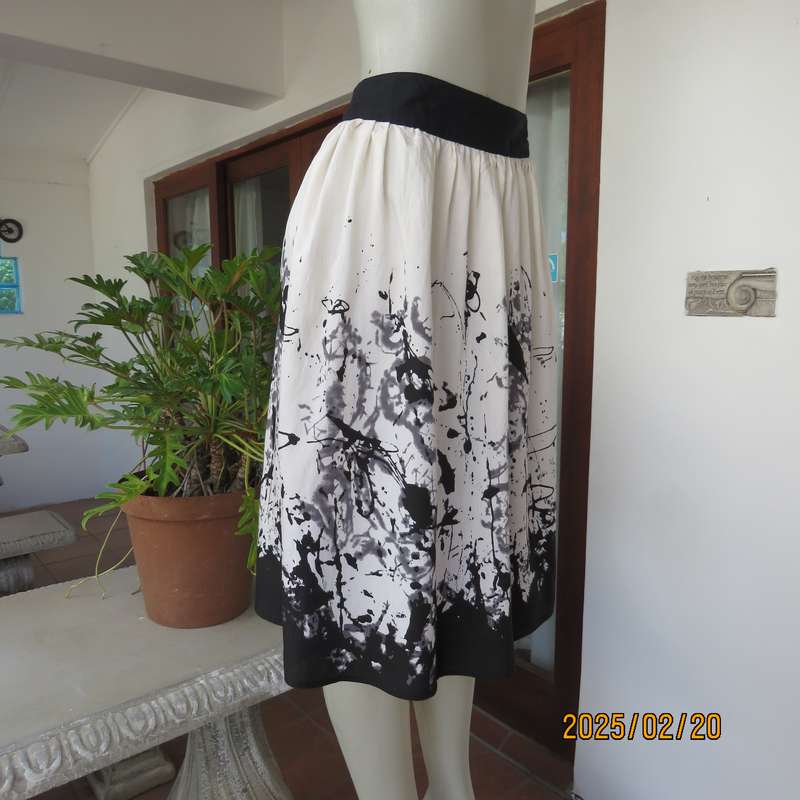 Unique rich cream size 42 viscose-nylon silky calf length skirt with graphic black print-border.
