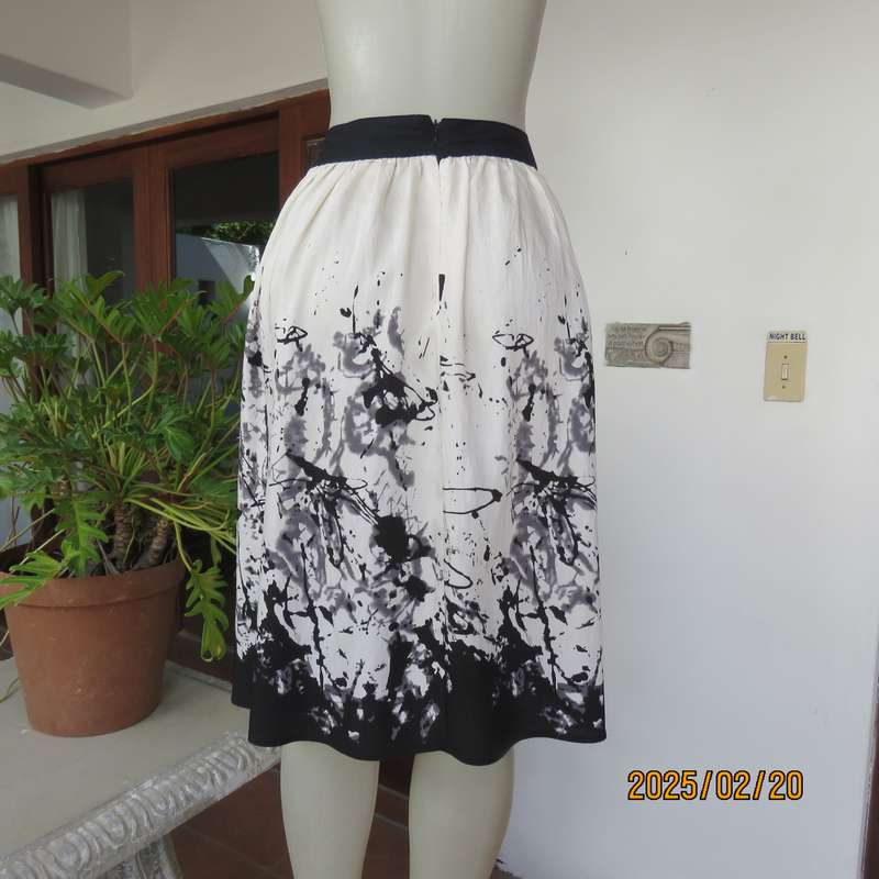 Unique rich cream size 42 viscose-nylon silky calf length skirt with graphic black print-border.