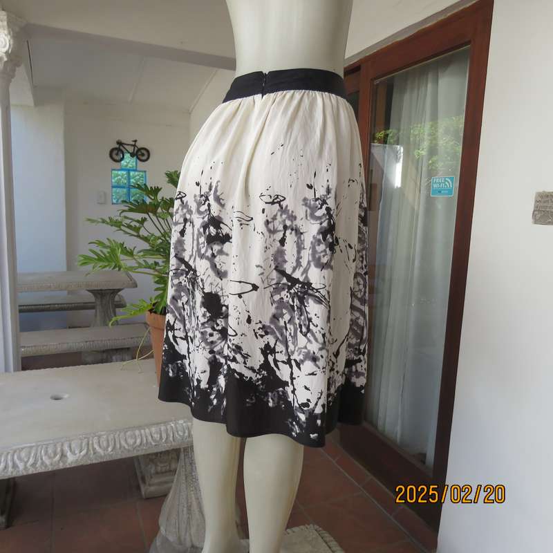 Unique rich cream size 42 viscose-nylon silky calf length skirt with graphic black print-border.