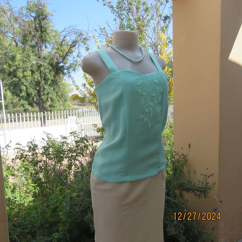 Beautiful emerald green embellished polyester top with shoulder straps. Size 37.Button down back.