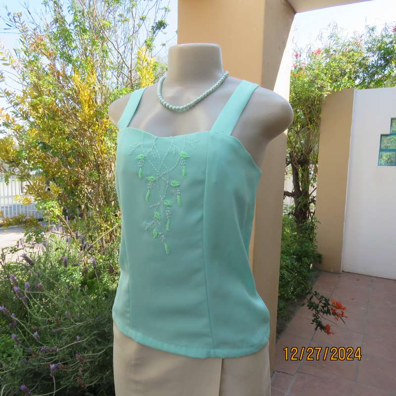 Beautiful emerald green embellished polyester top with shoulder straps. Size 37.Button down back.