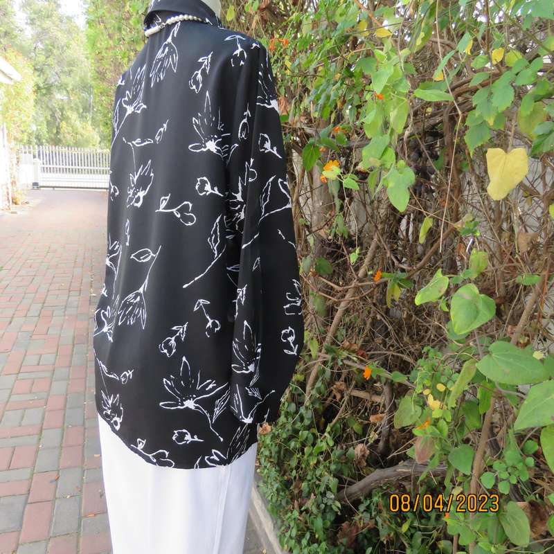 CONCEPTS black silky polyester top with white graphic floral print. Size 40.