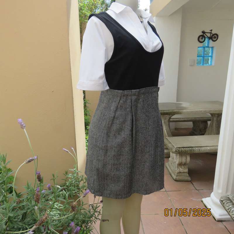 Unique pinafore with black stretch polyester top/black and white striped woolen bottom.Size 36.