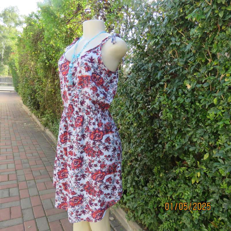 Cute little summer strappy dress in pale blue/rust/navy flowers. Size 36. Straps tie on shoulders.