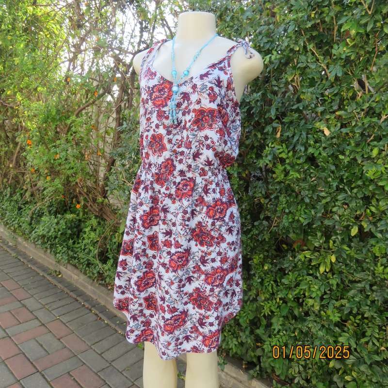 Cute little summer strappy dress in pale blue/rust/navy flowers. Size 36. Straps tie on shoulders.