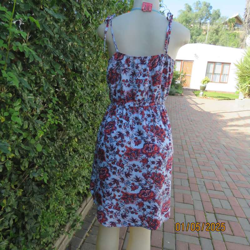 Cute little summer strappy dress in pale blue/rust/navy flowers. Size 36. Straps tie on shoulders.