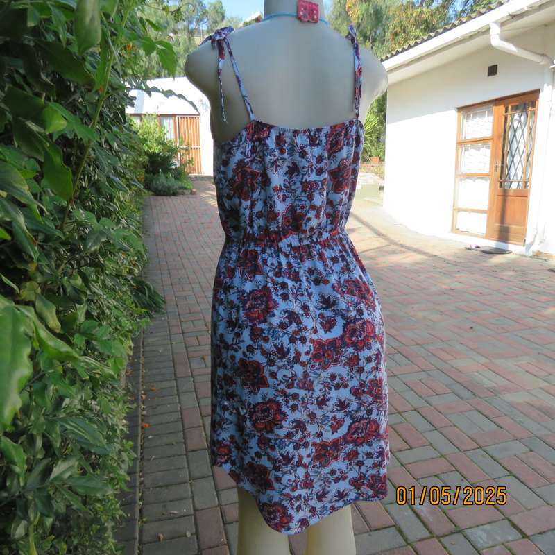 Cute little summer strappy dress in pale blue/rust/navy flowers. Size 36. Straps tie on shoulders.