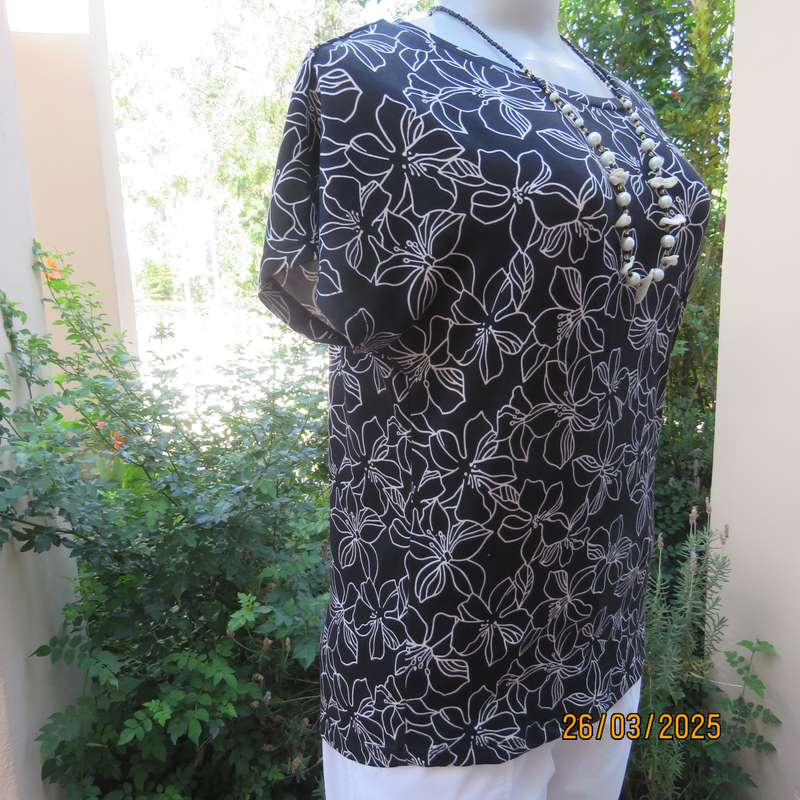 REAL basic black soft stretch polyester top with white lilies. Cut-on short sleeves. Size 36