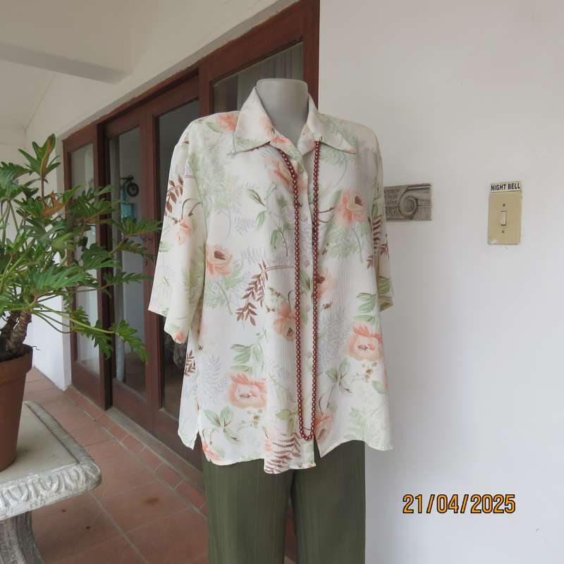Tastefully printed short sleeve cream crinkled polyester top with peach flowers. Size 44