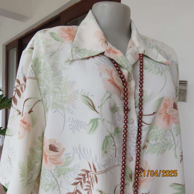 Tastefully printed short sleeve cream crinkled polyester top with peach flowers. Size 44
