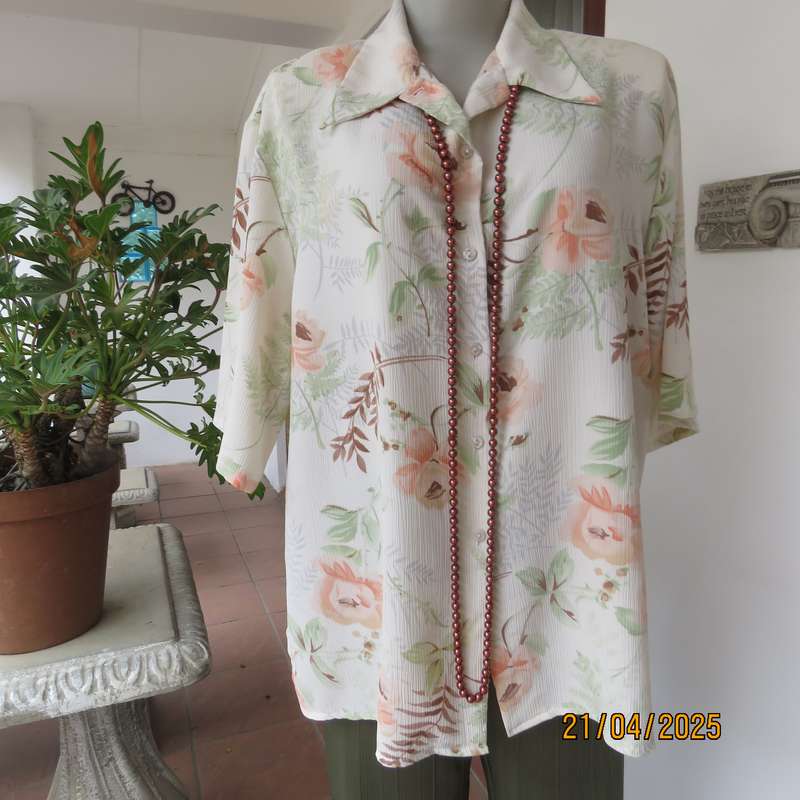 Tastefully printed short sleeve cream crinkled polyester top with peach flowers. Size 44