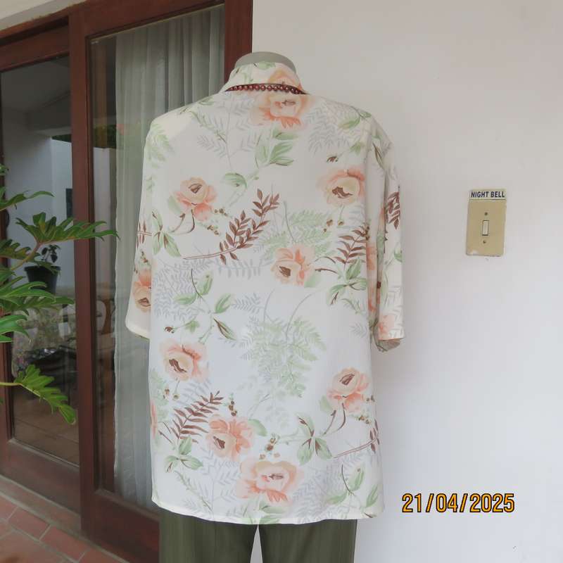 Tastefully printed short sleeve cream crinkled polyester top with peach flowers. Size 44