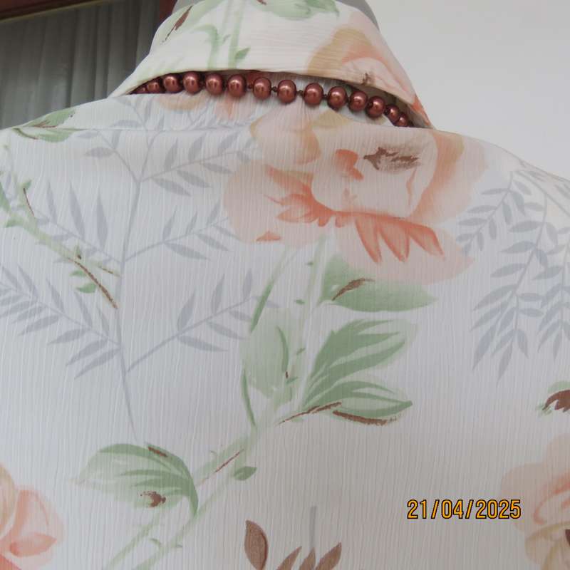 Tastefully printed short sleeve cream crinkled polyester top with peach flowers. Size 44