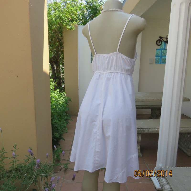 As new white slightly creased 100% cotton strappy dress. Size 36.Elasticated waist.Half flare skirt.