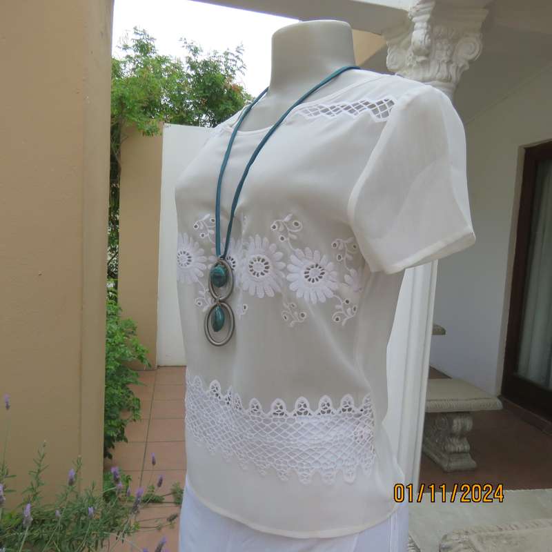 Dainty light cream short sleeve slip over sheer poly top.Bold floral embroidery on front.Size 32,