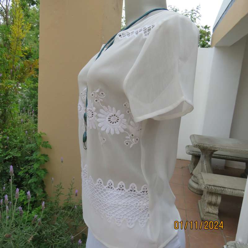 Dainty light cream short sleeve slip over sheer poly top.Bold floral embroidery on front.Size 32,