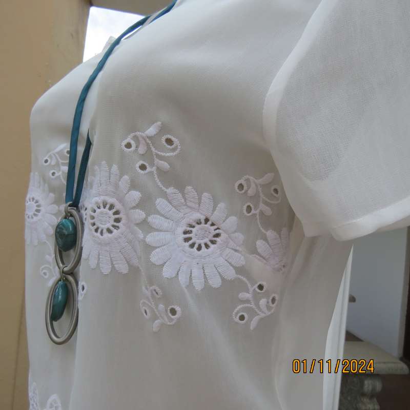 Dainty light cream short sleeve slip over sheer poly top.Bold floral embroidery on front.Size 32,
