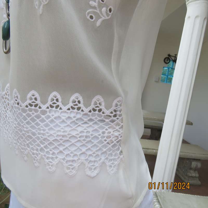 Dainty light cream short sleeve slip over sheer poly top.Bold floral embroidery on front.Size 32,