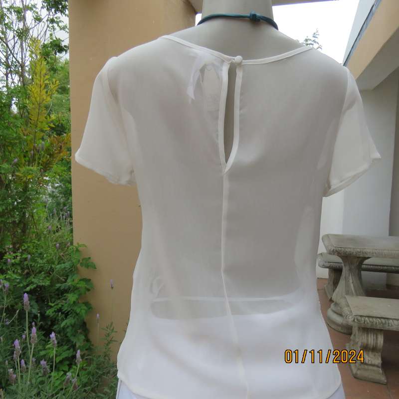 Dainty light cream short sleeve slip over sheer poly top.Bold floral embroidery on front.Size 32,