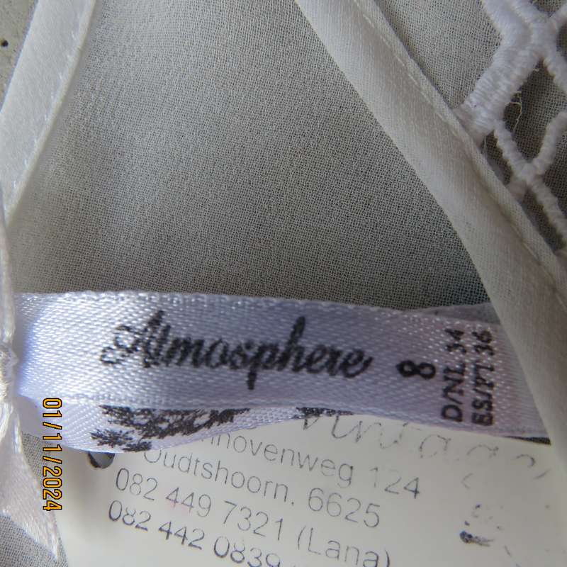 Dainty light cream short sleeve slip over sheer poly top.Bold floral embroidery on front.Size 32,