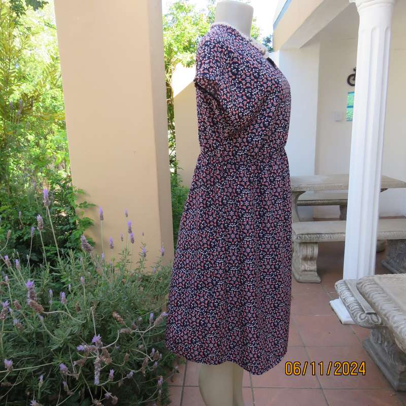 Cool maternity empire style dress in poly-rayon blend.Navy with white-pink flowers.Size 32-34.As new