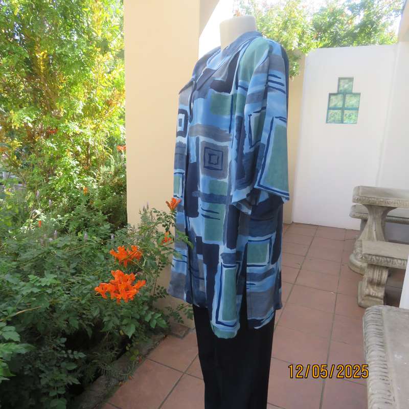 Short sleeve button down top in medley of blues. Geometric print in polyester. Size 44.