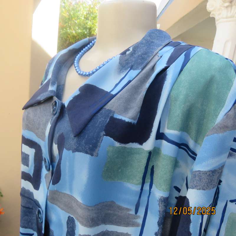 Short sleeve button down top in medley of blues. Geometric print in polyester. Size 44.