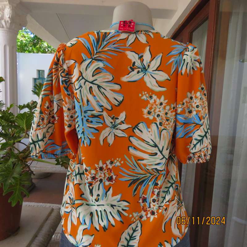 Eye catching slip over free hanging polyester top in burnt orange-blue and white flowers.Size 36.