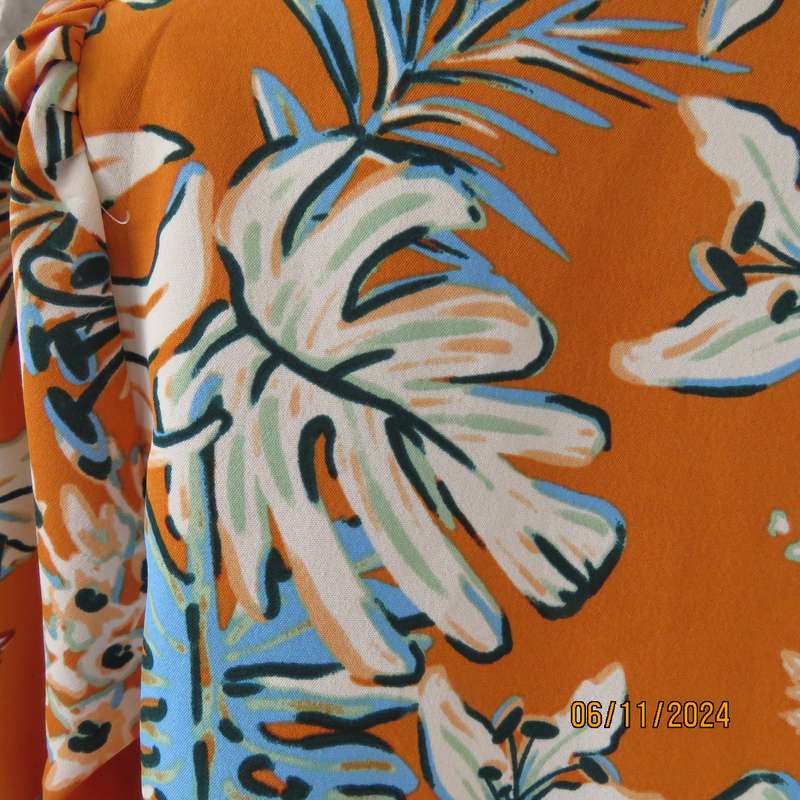 Eye catching slip over free hanging polyester top in burnt orange-blue and white flowers.Size 36.