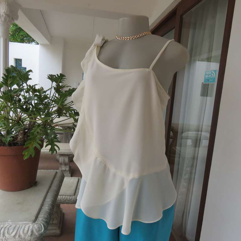 Dainty sheer polyester light cream strappy top with unique front frills.Size 38. By 1996 Premium.