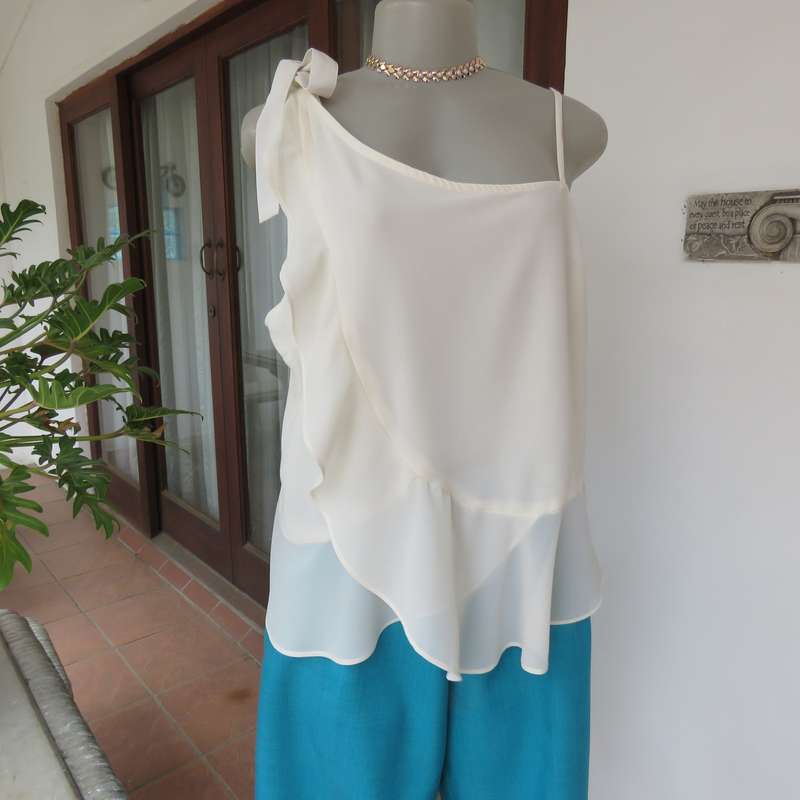 Dainty sheer polyester light cream strappy top with unique front frills.Size 38. By 1996 Premium.