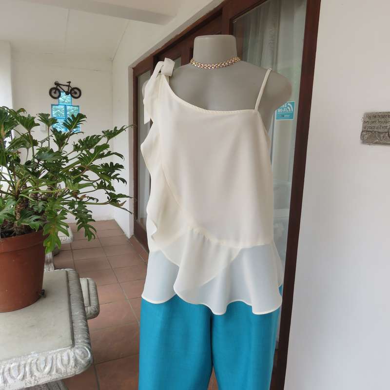 Dainty sheer polyester light cream strappy top with unique front frills.Size 38. By 1996 Premium.