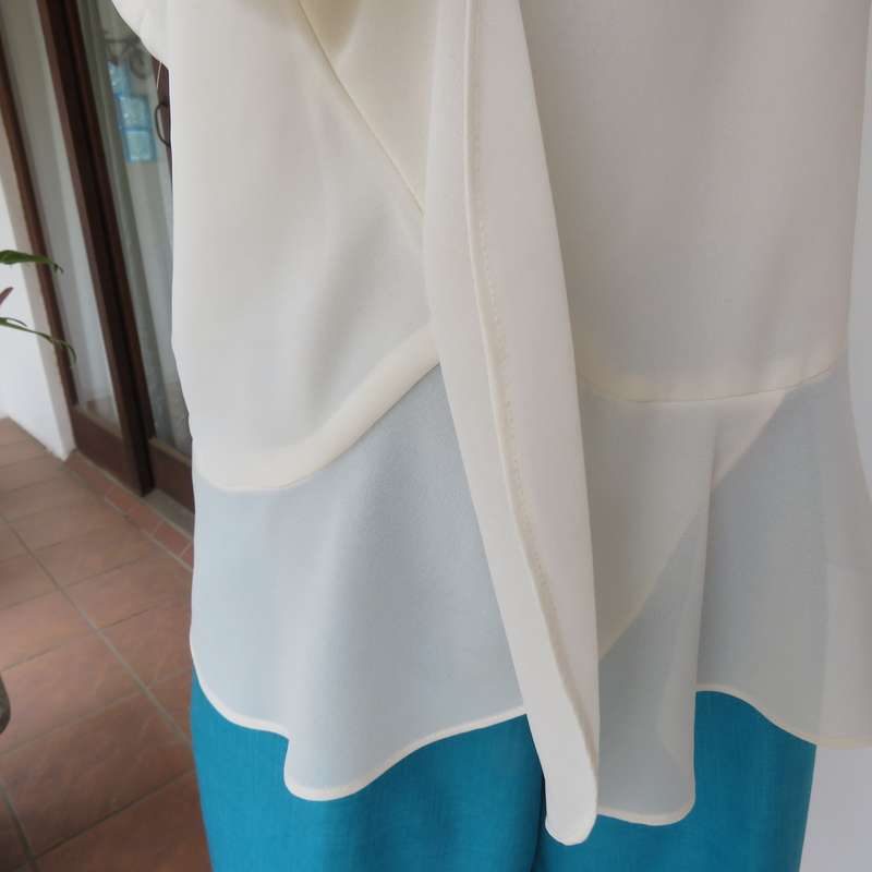 Dainty sheer polyester light cream strappy top with unique front frills.Size 38. By 1996 Premium.