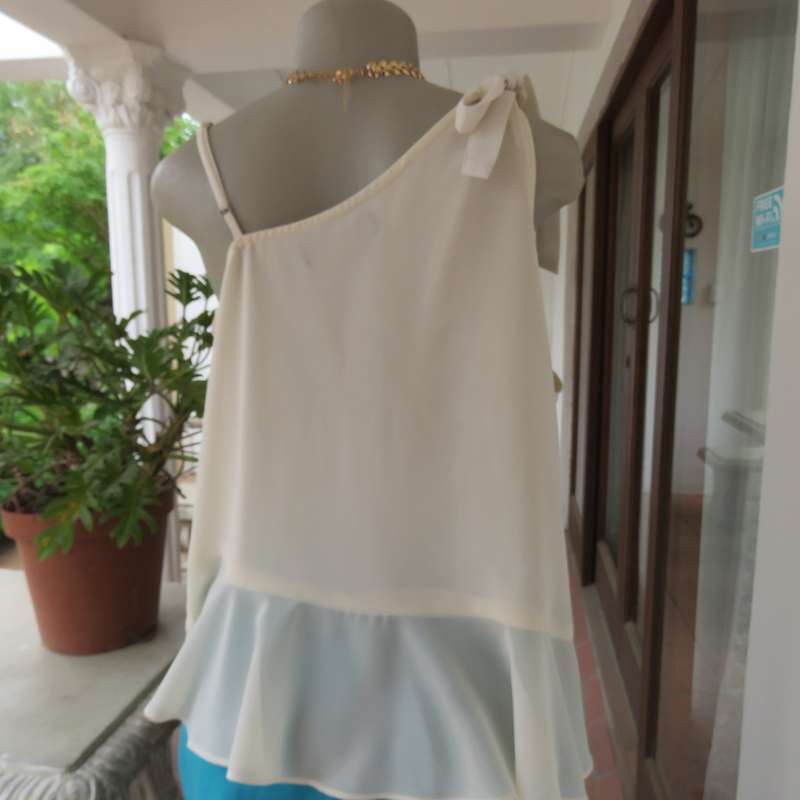 Dainty sheer polyester light cream strappy top with unique front frills.Size 38. By 1996 Premium.