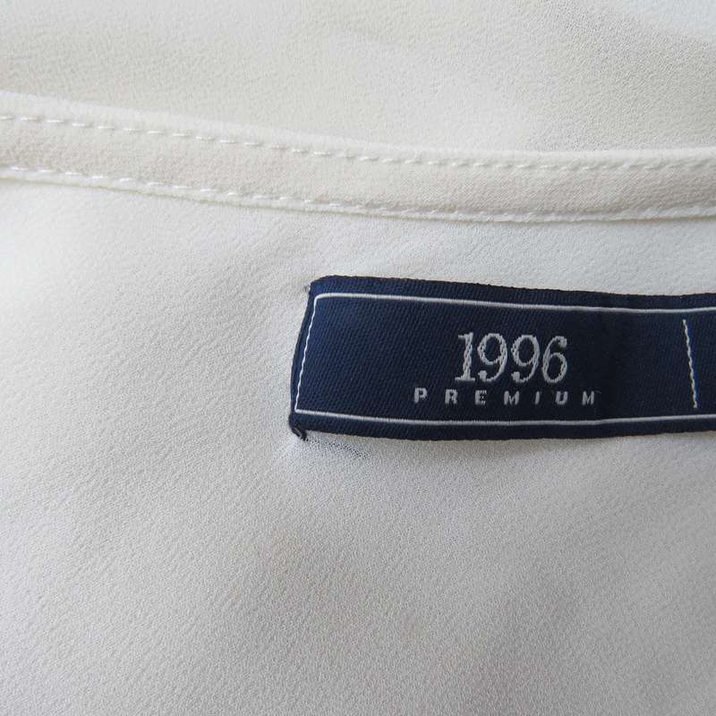 Dainty sheer polyester light cream strappy top with unique front frills.Size 38. By 1996 Premium.