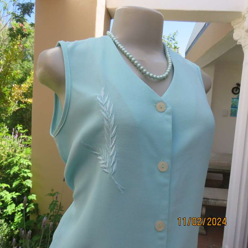 Look chic in this aqua colour sleeveless V neck top.Button down. Leaf embroidery.Size 34. As new