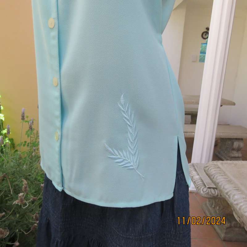 Look chic in this aqua colour sleeveless V neck top.Button down. Leaf embroidery.Size 34. As new