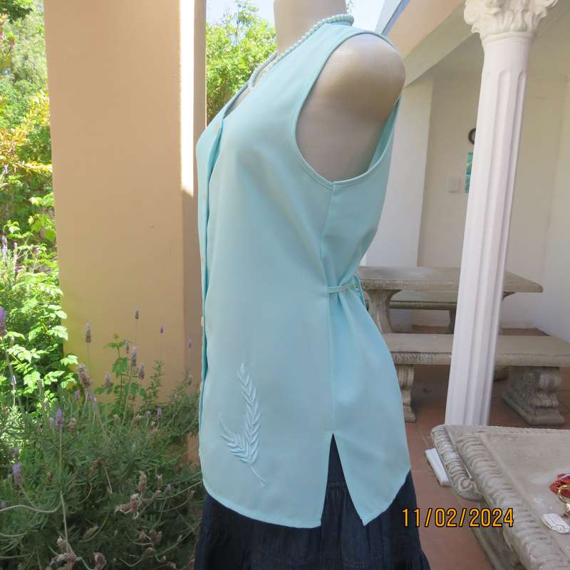 Look chic in this aqua colour sleeveless V neck top.Button down. Leaf embroidery.Size 34. As new