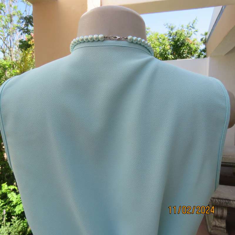 Look chic in this aqua colour sleeveless V neck top.Button down. Leaf embroidery.Size 34. As new