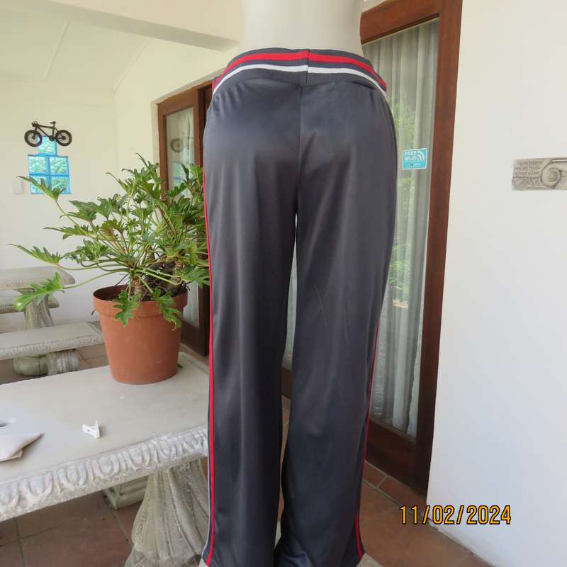 Steel grey track suit pants with wide stretch waistband in grey-red-silver. Size 38. Side stripes.