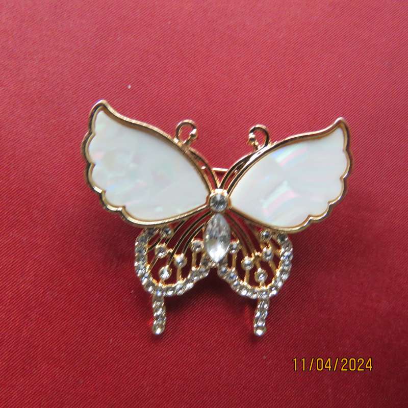 Butterfly brooch on gold colour with beautiful white shiny wings and tiny faux diamonds. New item.