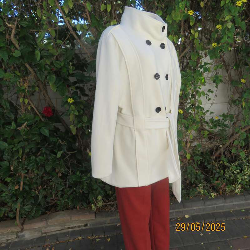 Light cream warm 100% polyester fully lined double breast jacket with belt. Size 44-46