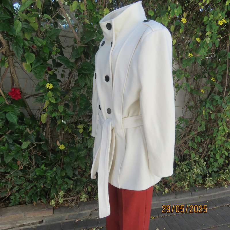 Light cream warm 100% polyester fully lined double breast jacket with belt. Size 44-46